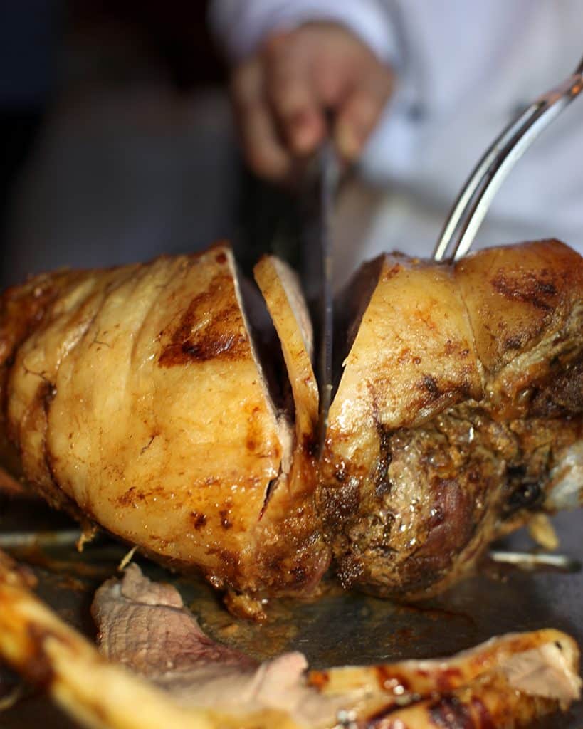 beautiful restaurant photography of leg of lamb being carved