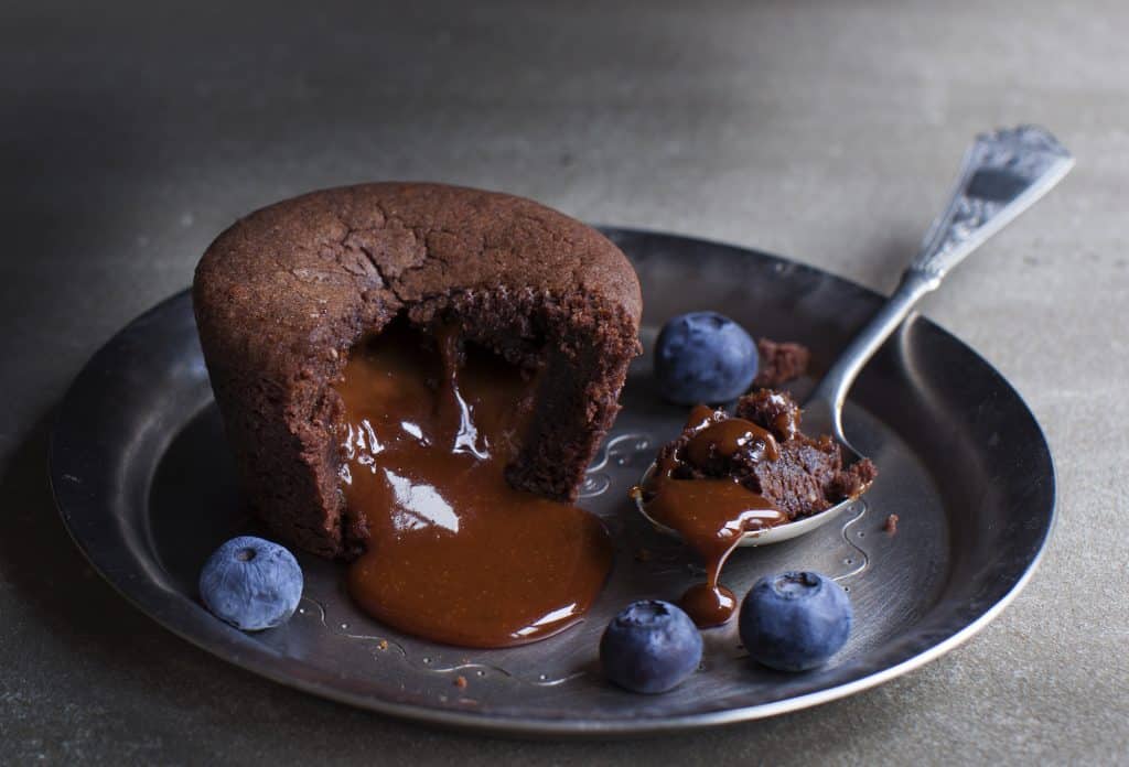 Oozing chocolate fondant on metal plate with blueberries