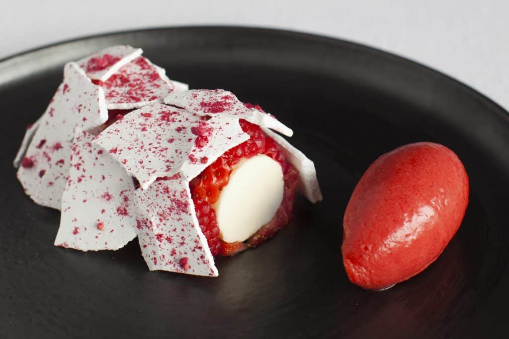 Strawberry meringue by Rocket Food on black plate